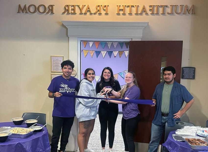 Members of the Converse community stand in front of the Multifaith Prayer Room cutting the ribbon for its grand opening.